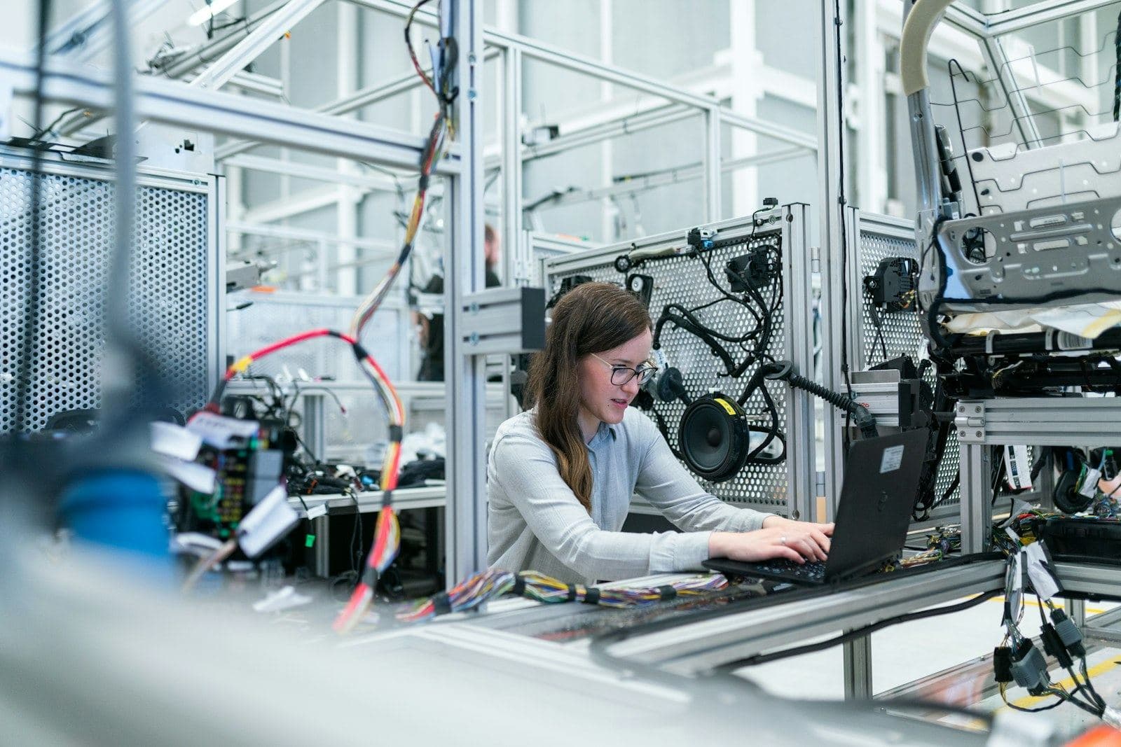 An engineer working on a laptop beside test machinery